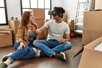 Young couple smiling happy playing with 3d vr glasses at new home.