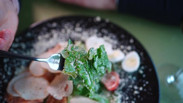 person eating resh caesar salad with lettuce, grilled chicken crusty bread toast