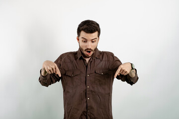 Handsome young man wearing casual clothes posing isolated over white background surprised and...