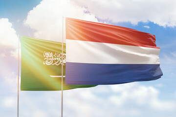Sunny blue sky and flags of netherlands and saudi arabia