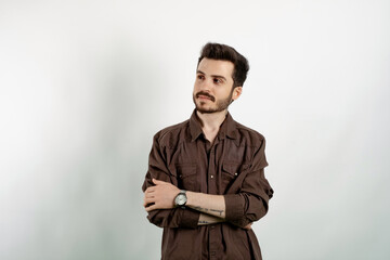 Obraz premium Handsome caucasian man wearing casual clothes posing isolated over white background keeping arms crossed and looking away with smile.