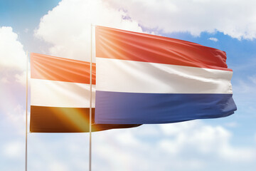 Sunny blue sky and flags of netherlands and yemen