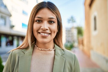 Young latin woman smiling confident at street