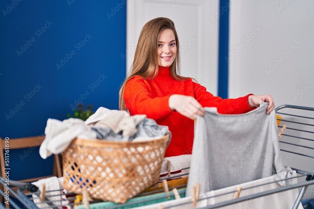 Canvas Prints Young blonde woman smiling confident hanging clothes on clothesline at laundry room