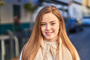 Young blonde woman smiling confident standing at street