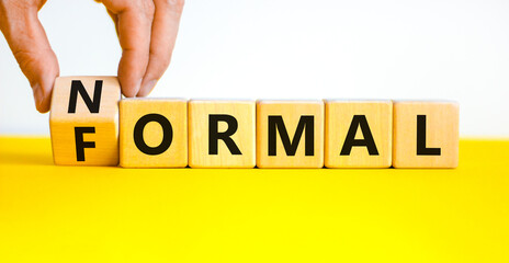 Formal or normal symbol. Businessman turns wooden cubes and changes the concept word formal to...
