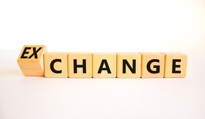 Change or exchange symbol. Turned wooden cubes and changed the concept word Change to Exchange. Beautiful white table white background. Copy space. Business and change or exchange concept.