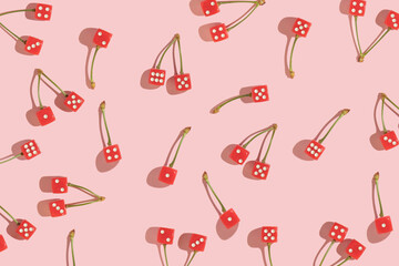 Summer creative pattern with red dices with cherry stems on pastel pink background. 70s, 80s or 90s retro fashion aesthetic fruit idea. Minimal summer romantic idea.