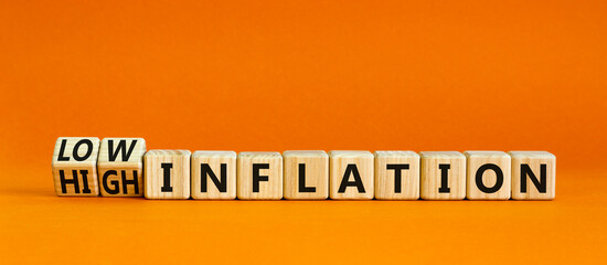 High or low inflation symbol. Turned wooden cubes and changed concept words High inflation to Low inflation. Beautiful orange background. Business and high or low inflation concept. Copy space.