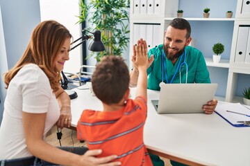 Family having medical consultation high five with hands raised up at clinic