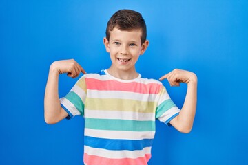 Young caucasian kid standing over blue background looking confident with smile on face, pointing oneself with fingers proud and happy.