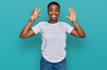 Young african american woman wearing casual white t shirt showing and pointing up with fingers number eight while smiling confident and happy.