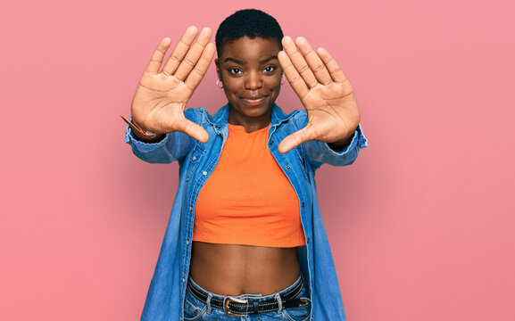 Young african american woman wearing casual clothes doing frame using hands palms and fingers, camera perspective