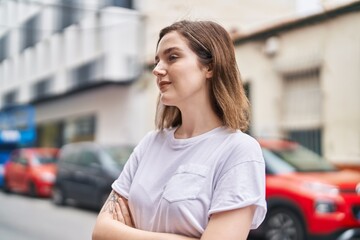 Young woman smiling confident standing with arms crossed gesture at street