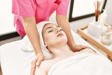 Fototapeta na wymiar Young caucasian woman relaxed reciving massage at beauty center.