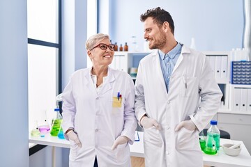 Mother and son scientist partners standing at laboratory