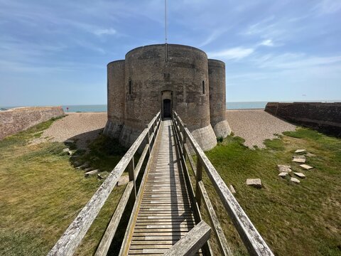  Landscape with Martello tower historic stone forts built as 19th century sea defences on East Anglia coastline Aldeburgh beach Suffolk uk with wooden bridge over moat in Summer blue skies 