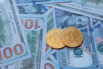 Bitcoin falls concept photo. Two bitcoins on US dollars.
