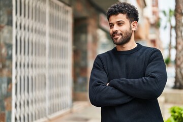 Young arab man smiling confident standing with arms crossed gesture at street