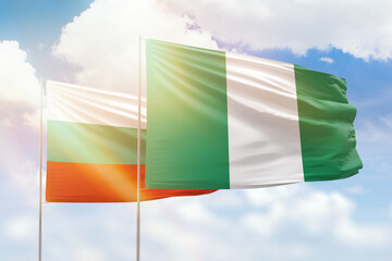 Sunny blue sky and flags of nigeria and bulgaria