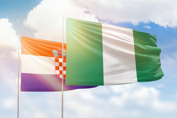 Sunny blue sky and flags of nigeria and croatia