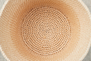 Fototapeta na wymiar natural beige raffia summer hat on textile background