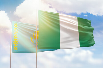 Sunny blue sky and flags of nigeria and kazakhstan