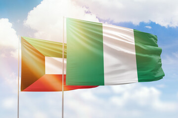 Sunny blue sky and flags of nigeria and kuwait