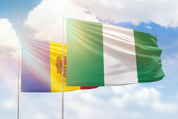 Sunny blue sky and flags of nigeria and moldova
