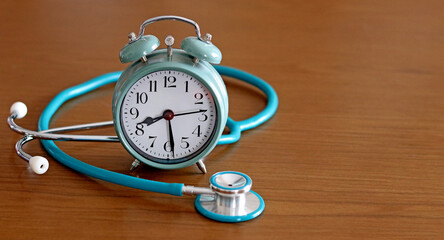 A stethoscope next to an alarm clock. Concept of time to take care of health.