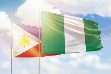 Sunny blue sky and flags of nigeria and philippines