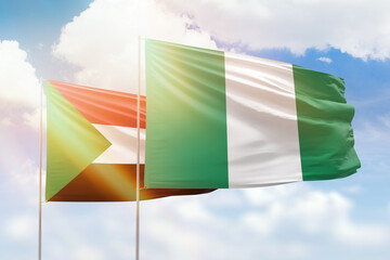 Sunny blue sky and flags of nigeria and sudan