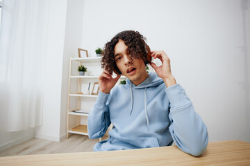 A young man sitting at a table in front of a computer music interior