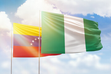 Sunny blue sky and flags of nigeria and venezuela