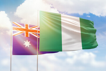 Sunny blue sky and flags of nigeria and australia