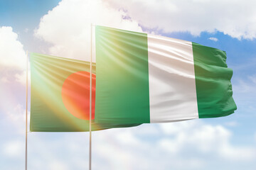Sunny blue sky and flags of nigeria and bangladesh