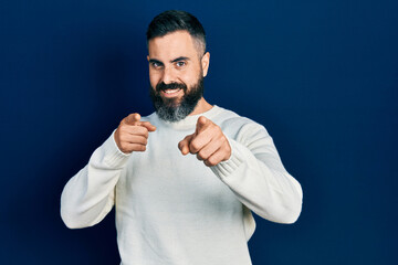 Young hispanic man wearing casual clothes pointing fingers to camera with happy and funny face. good energy and vibes.