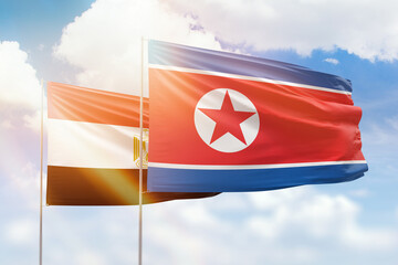 Sunny blue sky and flags of north korea and egypt