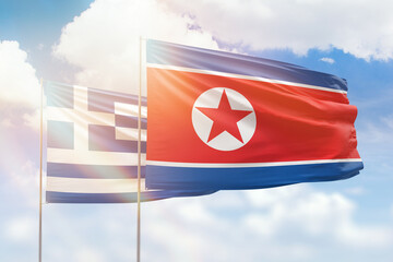 Sunny blue sky and flags of north korea and greece