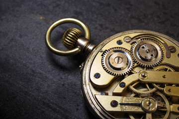 Obraz na płótnie Canvas Vintage swiss clockwork mechanism. Silver pocket watch on stone background