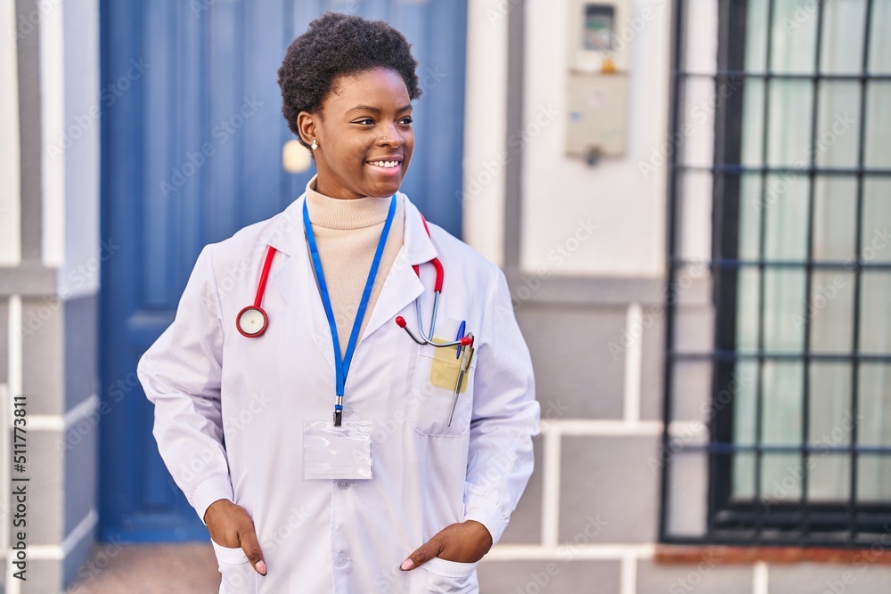 Wall mural African american woman wearing doctor uniform standing at street