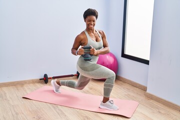 African american woman smiling confident training legs exersice at sport center - Powered by Adobe