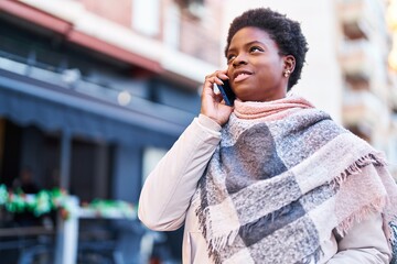 African american woman smiling confident talking on the smartphone at street