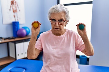 Senior woman with grey hair holding hands strength balls depressed and worry for distress, crying angry and afraid. sad expression.