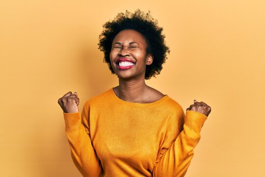 Young african american woman wearing casual clothes very happy and excited doing winner gesture with arms raised, smiling and screaming for success. celebration concept.