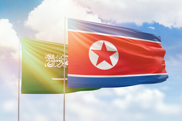 Sunny blue sky and flags of north korea and saudi arabia