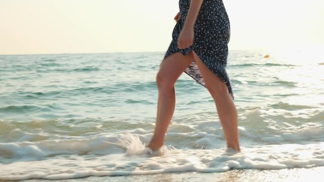 Pretty woman at the beach. Happy girl enjoying summer morning walking near the sea.