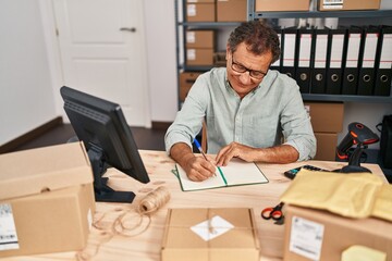 Middle age man ecommerce business worker writing on book at office