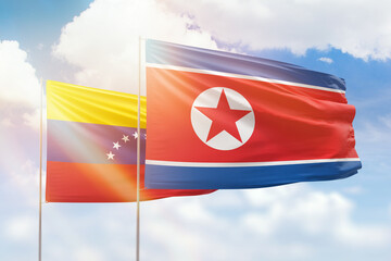 Sunny blue sky and flags of north korea and venezuela