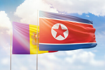 Sunny blue sky and flags of north korea and andorra